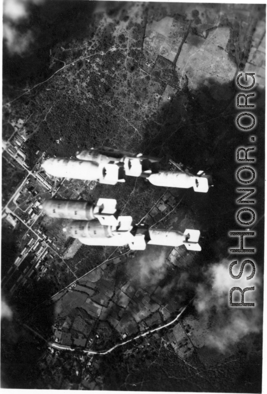Bombs fall over tidy buildings in Burma or French Indochina, in the CBI, during WWII.