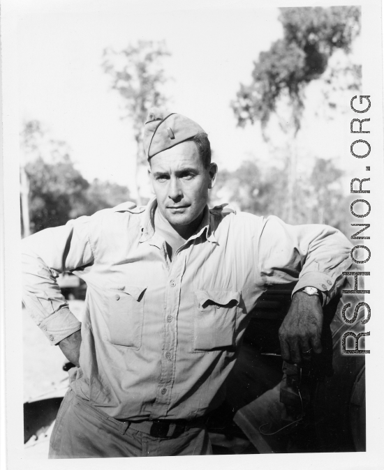Engineer of the 797th Engineer Forestry Company poses against truck in Burma.  During WWII.