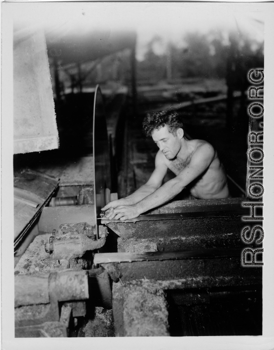 GI of the 797th Engineer Forestry Company in Burma, adjusting saw blade guide in mill.  During WWII.