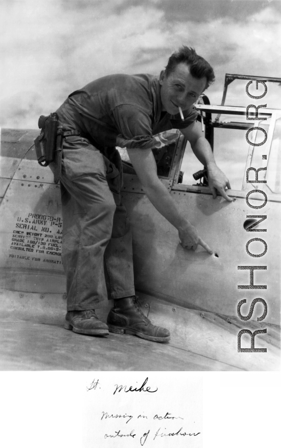 Henry E. Miehe, pointing to battle damage on his airplane. China, WWII.