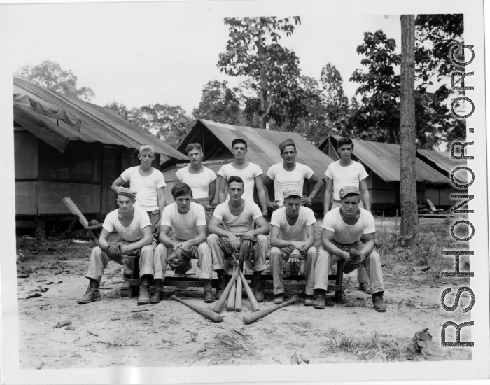 Engineers of the 797th Engineer Forestry Company pose outside tents with baseball gear in Burma.  During WWII.