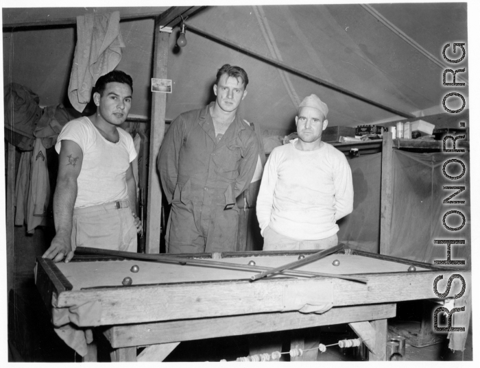 Engineers of the 797th Engineer Forestry Company pose while playing at a miniature pool table in their tent in Burma.  During WWII.