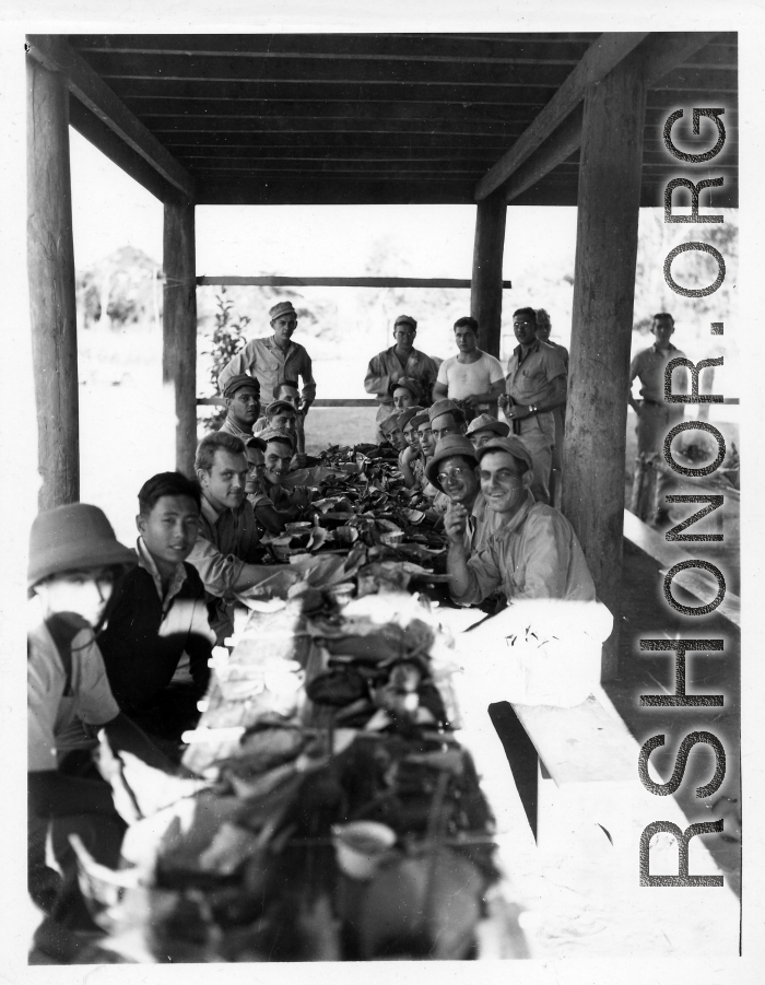 Engineers of the 797th Engineer Forestry Company eating fancy meal in Burma, possibly in the stilt space under a private home.  During WWII.