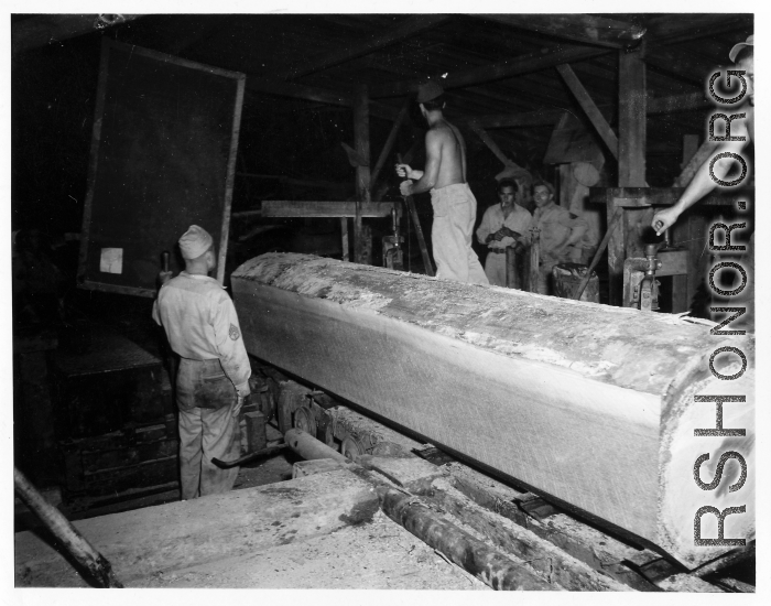 Operations of a mill of the 797th Engineer Forestry Company in Burma--a clear grain log cant on the mill.  During WWII.