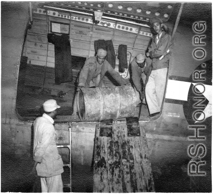 Chinese workers unloading barrels from a C-46 transport during WWII.