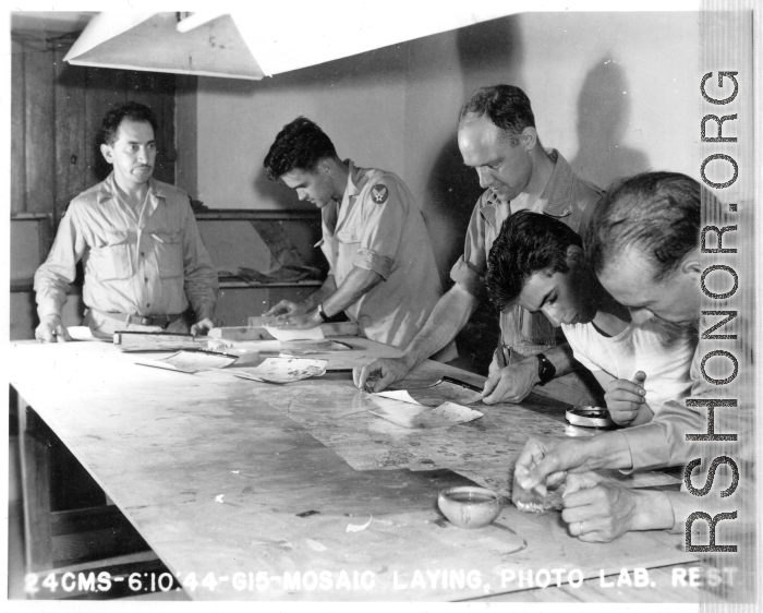 "Mosaic laying" at photo lab of the 24th Mapping Squadron--cutting and pasting numerous high-resolution aerial images together onto a board to create a wide view. June 10, 1944.