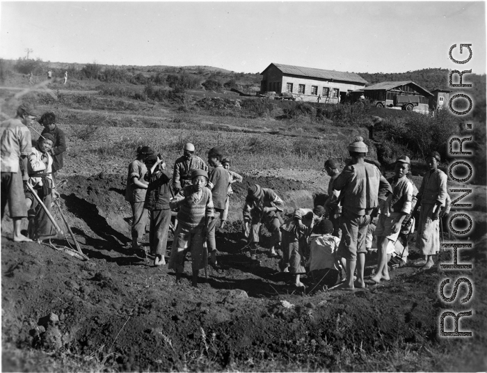 Workers dig pit outside a beef slaughterhouse at Yangkai, set up specifically to provide meat for base personnel. During WWII.