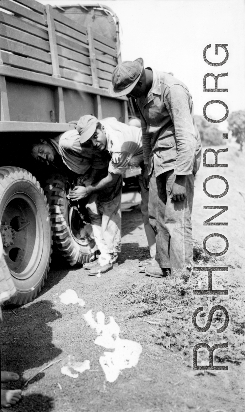 American servicemen--including an African-American serviceman--work on a truck along some road somewhere in the CBI during WWII.  From the collection of Wozniak, combat photographer for the 491st Bomb Squadron, in the CBI.