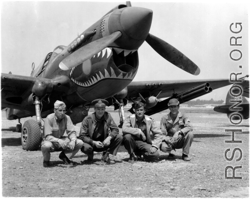 American GIs pose with shark-teeth painted P-40 fighter in the CBI.