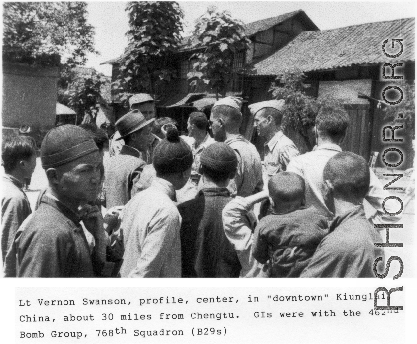 Lt. Vernon Swanson, profile, center, in downtown Qionglai (Kiunglai), China, about 30 miles from Chengtu, during WWII. GI were with the 462nd Bomb Group, 768th Squadron (B-29s).