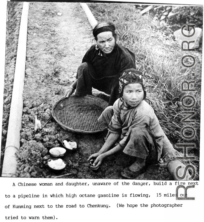 A Chinese woman and child start a fire next to a pipeline in which gasoline is flowing, 15 miles out of Kunming, next to the road to Chenggong (Chengkung). During WWII.