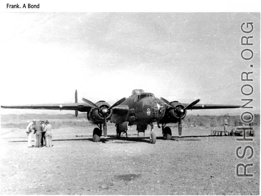 The "Skull & Wings" insignia on plane's side near the nose indicates this parked B-25J Mitchell is assigned to 490th Bomb Squadron, 341st Bomb Group.  The 490th had stayed in India, attached to Tenth Air Force, when 341st BG moved from to China in January 1944. With aerial combat finished in Burma, the 490th BS (attached to 312 Fighter Wing) moved in late April 1945 to Hanzhong (Han-chung), southwestern Shaanxi sheng (province), central China.  Images from Frank A. Bond.  (Additional information courtesy of