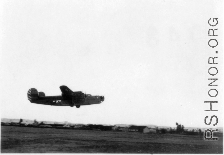 A B-24 in the air over a runway in the CBI during WWII.  Image provided by Emery and Beth Vrana.