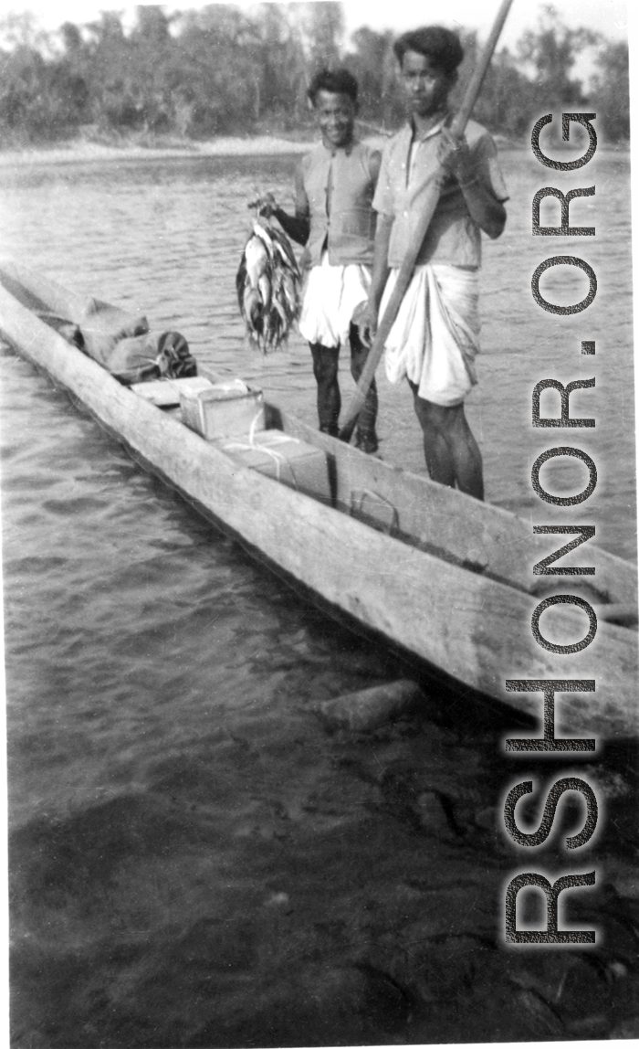 Two men near Misamari, India, show off a tidy string of fish as they stand next to their very long canoe.   Image provided by  "P. Noel."   In the CBI during WWII.