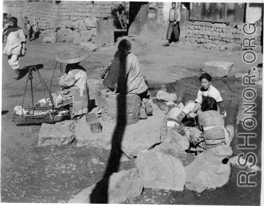 Chinese women washing either cotton or silk cocoons during WWII, in a village in China, probably in Yunnan province.  From the collection of Wozniak, combat photographer for the 491st Bomb Squadron, in the CBI.