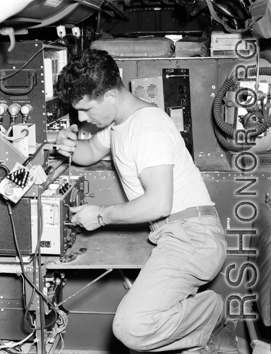 An American serviceman works on electrical equipment in an aircraft in the CBI during WWII.  This image was scanned at high resolution from the original negative and the clarity and detail is exceptional. the white box in the upper right corner is labelled "Desiccated Normal Human Plasma," testifying to the deadly seriousness of the business of these aircraft and their crews.
