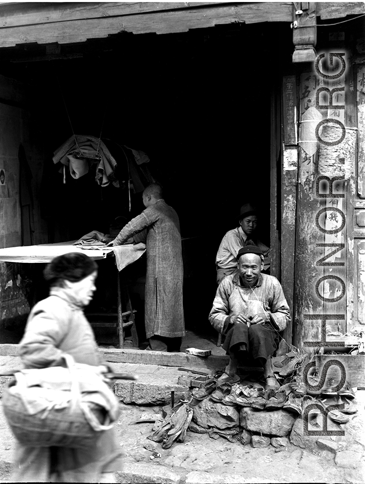 A small shop with local people and  in China, including a cobbler and tailor.  From the collection of Eugene T. Wozniak.