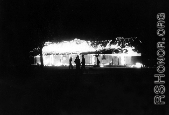 A building on fire at an American base, China, during WWII. Most likely during the retreat in the face of Ichigo in 1944.