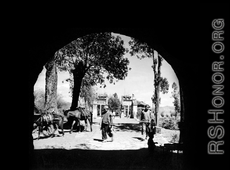 People as seen through a large town gate in Yunnan province, China, during WWII.