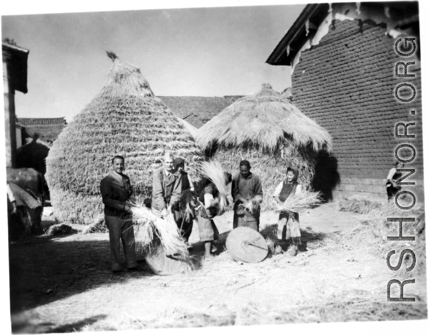 American GIs and people in a local village in Yunnan province, China, threshing grain by striking the rice straw against grinding stones.  From the collection of Eugene T. Wozniak.