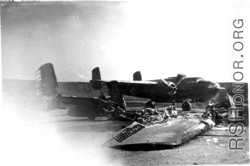 In the foreground of this revetment are the remains of a North American B-25 bomber, like the one in the background, after it burnt up. This was possibly due to a night attack by Japanese bombers.