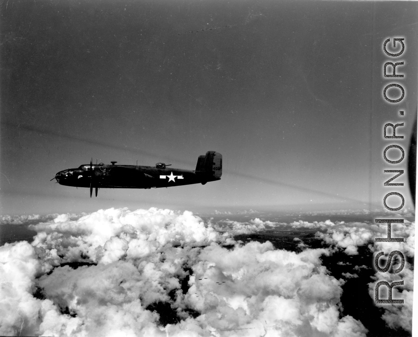 B-25 Mitchell bombers in flight in the CBI, in the area of southern China, Indochina, or Burma. Notice the group further away against clouds at the bottom of the image.