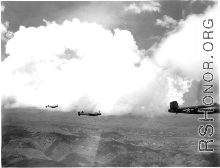 B-25 Mitchell bombers and P-38s in flight in the CBI, in the area of southern China, Indochina, or Burma.