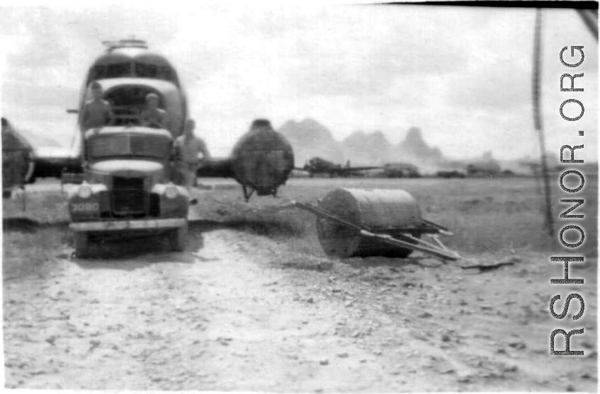 American mechanics of the 12th Air Service Group carefully ease the fuselage of a C-47 past a large concrete roller. In Guangxi, China, during WWII.