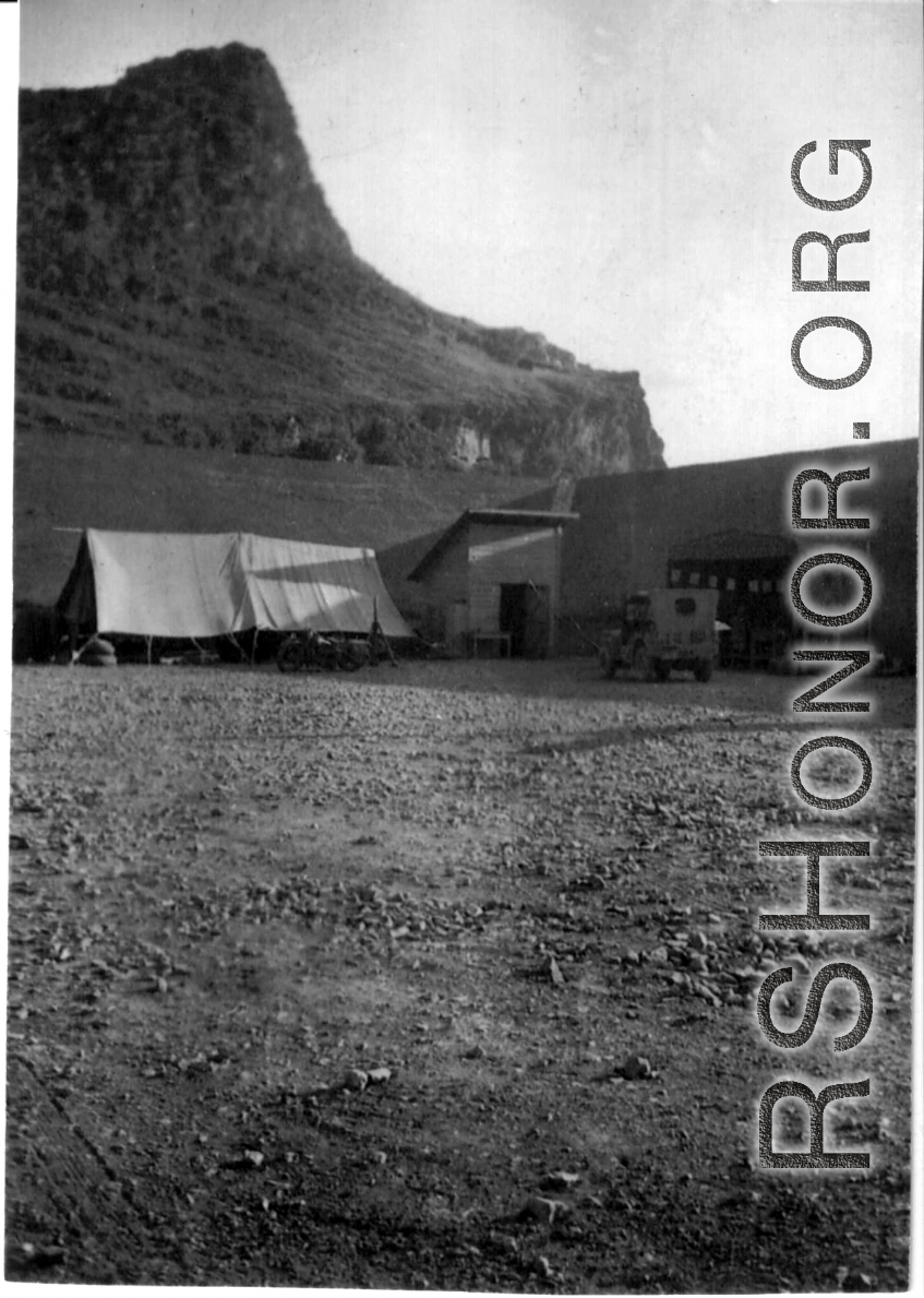 "The Latest In Shops And Equipment--This a picture looking into a revetment that served as our work area and engineering area at Luichow [Liuzhou], China. Lt. Sohl's office was in the little shack at the right and all our tools and equipment was in the tent. We changed a lot of B-24 engines in this revetment along with replacing blown out tires and doing sheet metal repair work. We worked here until the Japanese forced us to evacuate the base and return to Luliang."