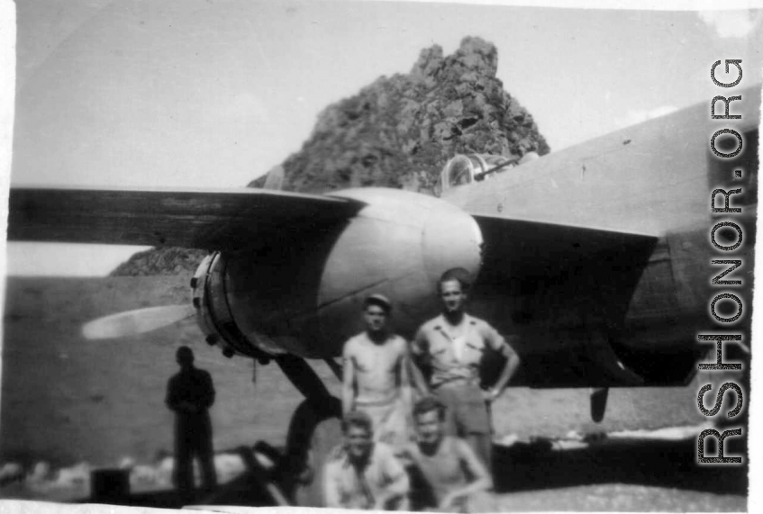 12th Air Service Group men pose in revetment with B-25 in Guangxi, before a karst peak. During WWII.