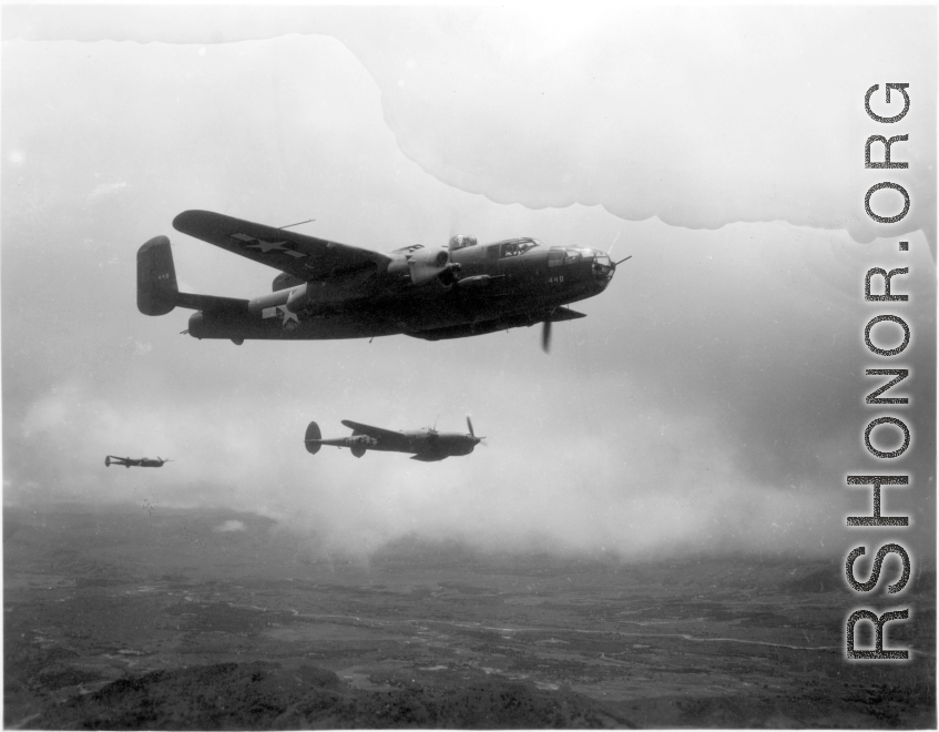 B-25 Mitchell bomber, tail number #448, and P-38s in flight in the CBI, in the area of southern China, Indochina, or Burma.