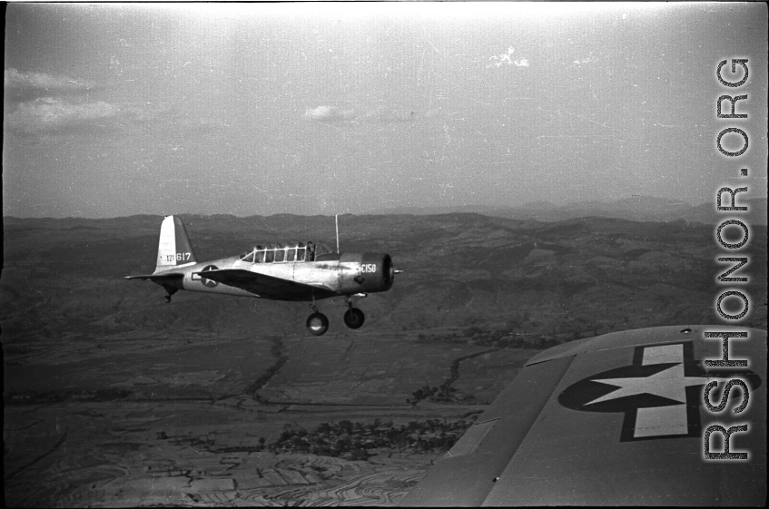 A  Vultee SNV-2 (a variant of the BT-13) trainer off the wing of another SNV-2, piloted by Charles Breingan, over China during WWII.