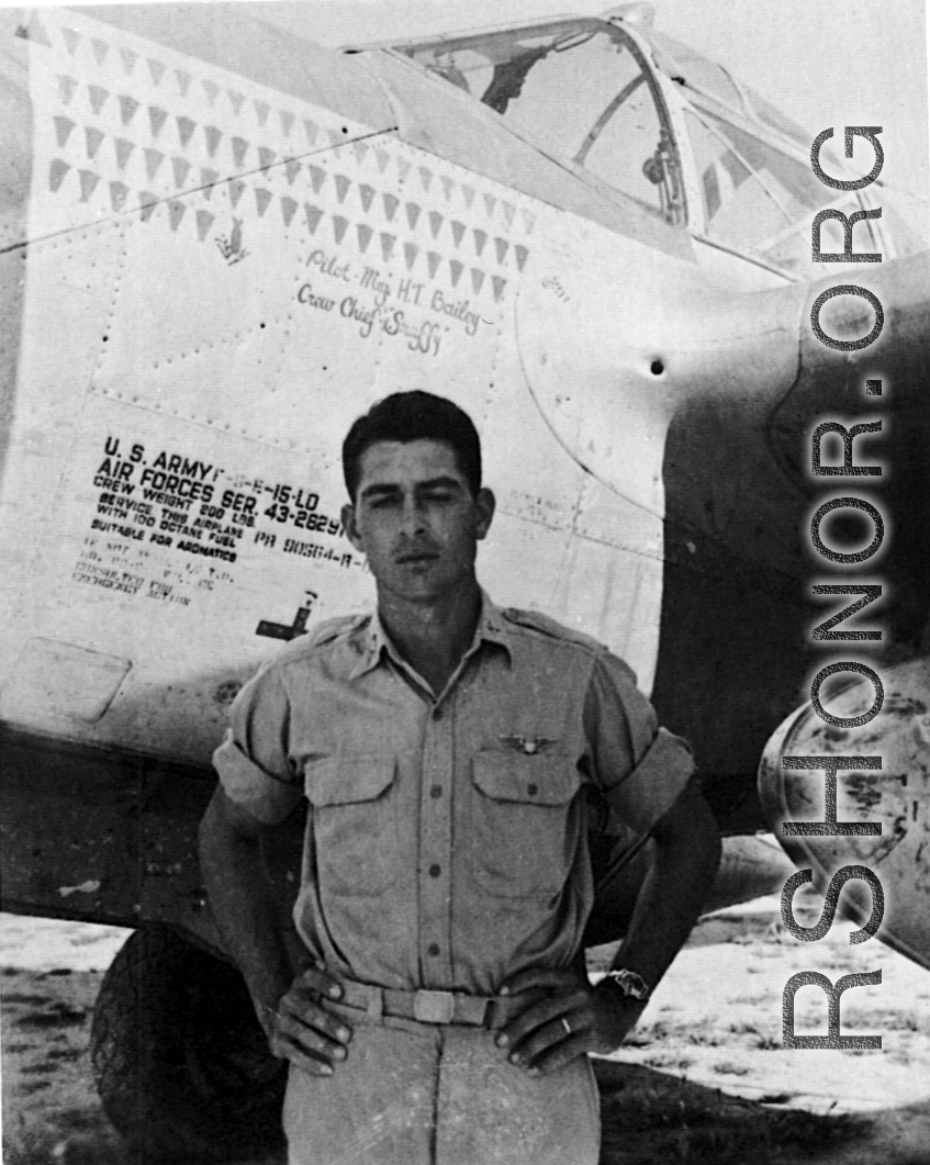 A man poses before the F-5 (a variant of the P-38) 'Mary Ann' piloted by Major H. T. Bailey, who had a crew chief "Snaffy".