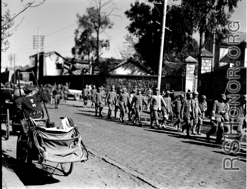 Chinese soldiers walking on a road in Kunming during WWII.