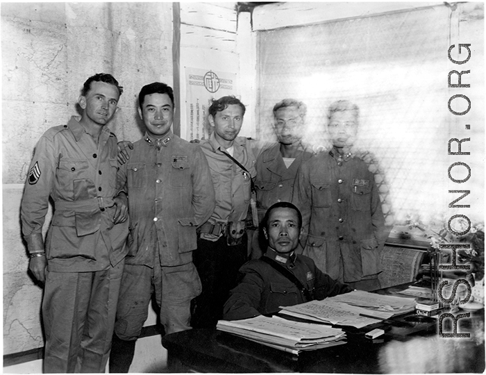  A very emaciated and wary-looking Zheng Tingji (郑庭笈), commander of the 48th Army Division (陆军第四十八师 ), poses at his desk in Yunnan, with GIs and more junior Chinese officers. Eugene T. Wozniak, arms around Chinese comrades, standing in the middle.