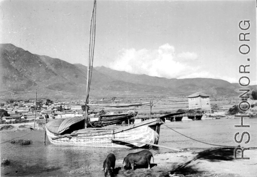 A wooden boat and stone tower at Xiaguan Township (下关), in western Yunnan province, along the route of the Burma Road, and at the outlet of Erhai Lake (洱海). During WWII.