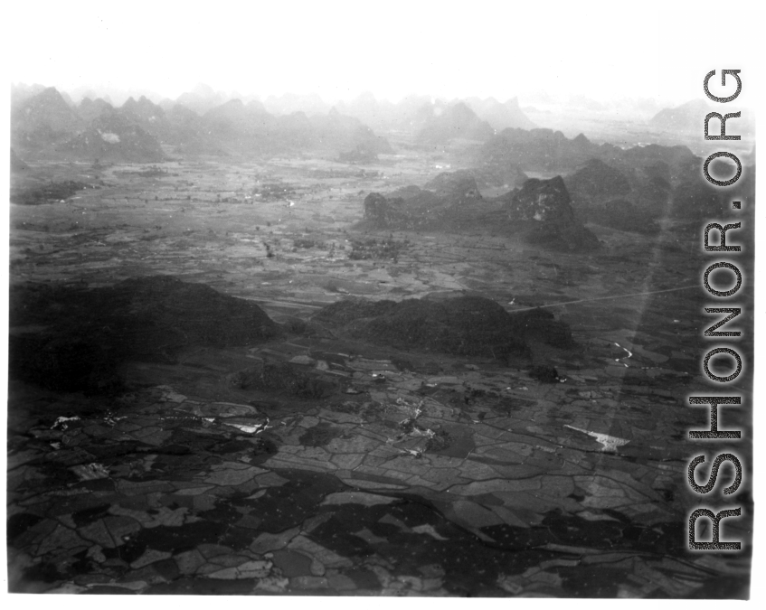 Aerial view of karst mountains and fields in either SW China or French Indochina, in the CBI, during WWII.