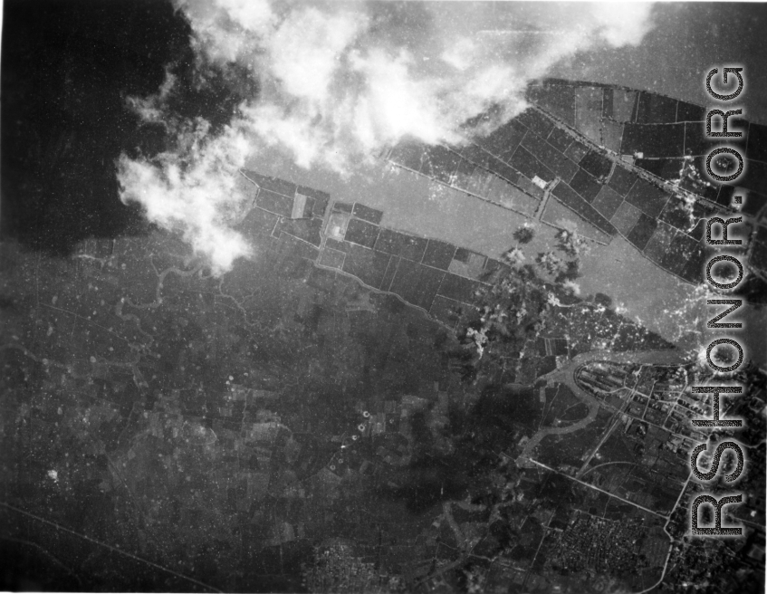 Explosions during bombing of small riverside town in either SW China (esp. Guangxi),  Burma, or French Indochina. During WWII. Signs of previous bombings are visible about, including bomb craters here and there.