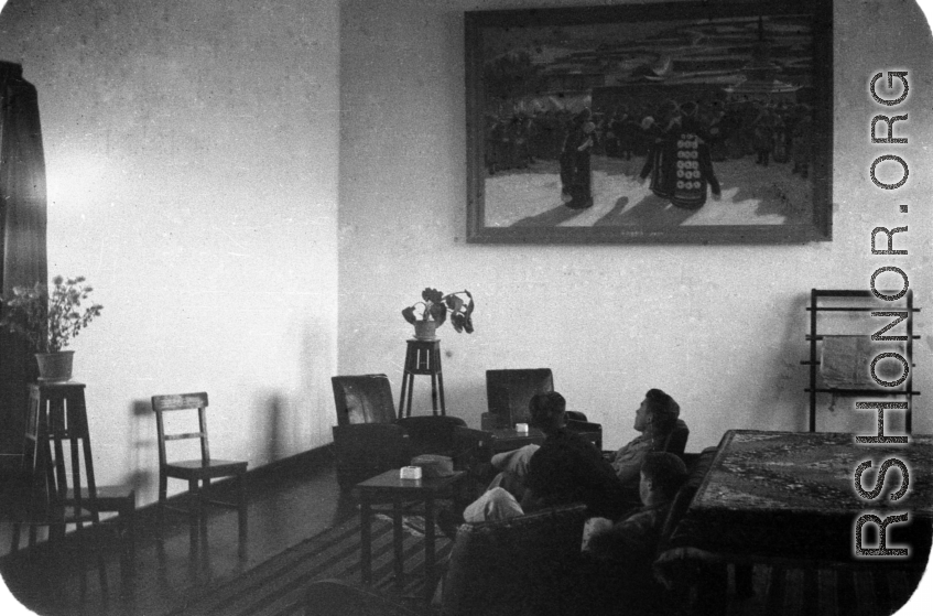 GIs rest in a nice room, under a large portrait of a Tibetan pilgrimage to a Tibetan Buddhist temple.  Probably in Lanzhou or nearby. During WWII.