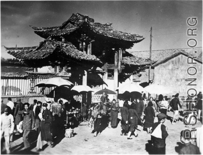 Local people in Yunnan province, China, during WWII: People come and go through gate.