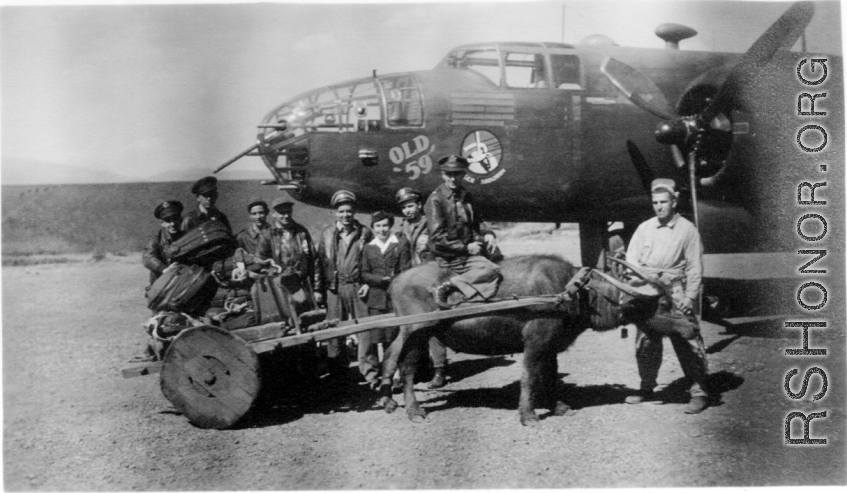 The crew of "Old 59", and well-wisher Barbara Vatter (American Red Cross Nurse at Yangkai) pose for a photo as the crew, after many, many combat missions, prepares to return to the USA. Once back in America they were scheduled to participate in a war bond tour.  Frank Bates had noted, "That's Bill Murphy holding the bull." The crew stands behind the cart, from the left, Capt. Robert Ebey (pilot), Lt Paul Sjoberg (cp), Sgt Francis Donnelly (rg), S/Sgt Lyle Wilson (eg), S/Sgt Rudolph Madsen (ag), Barbara Vatt