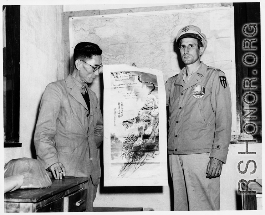 A Chinese representative of the Air Transport Office of the SYEHA WTB presents a picture to commemorate the 38th anniversary of the USAAF to an officer of the ATC at Chanyi, China. During WWII.