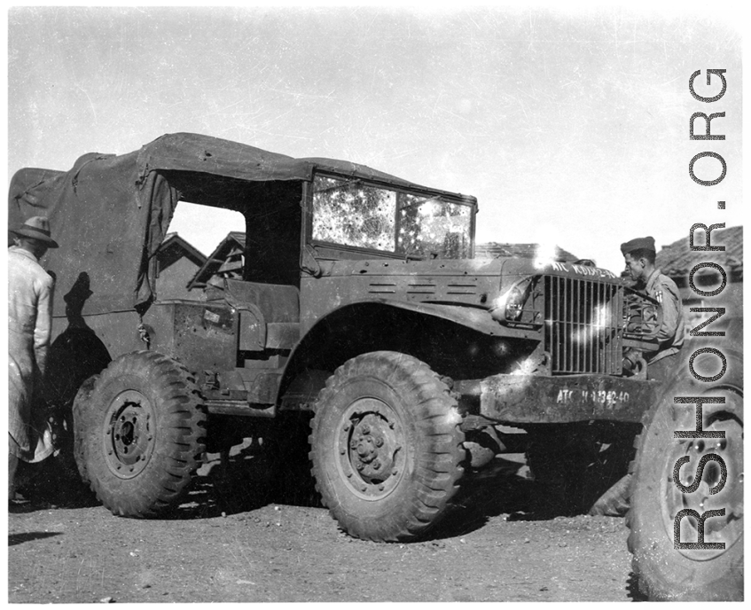 Men repair a damaged ATC ground transport vehicle, damaged by shrapnel or bullets. In China during WWII.
