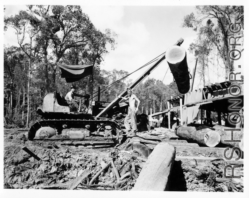 Site at the mill yard, a tracked loader feeding logs to saw line at a lumber mill of the 797th Engineer Forestry Company in Burma.  During WWII.