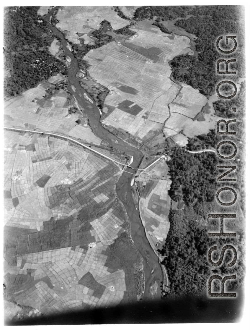 Aerial view of Burma Road bridge under construction amid rice paddies.  During WWII.
