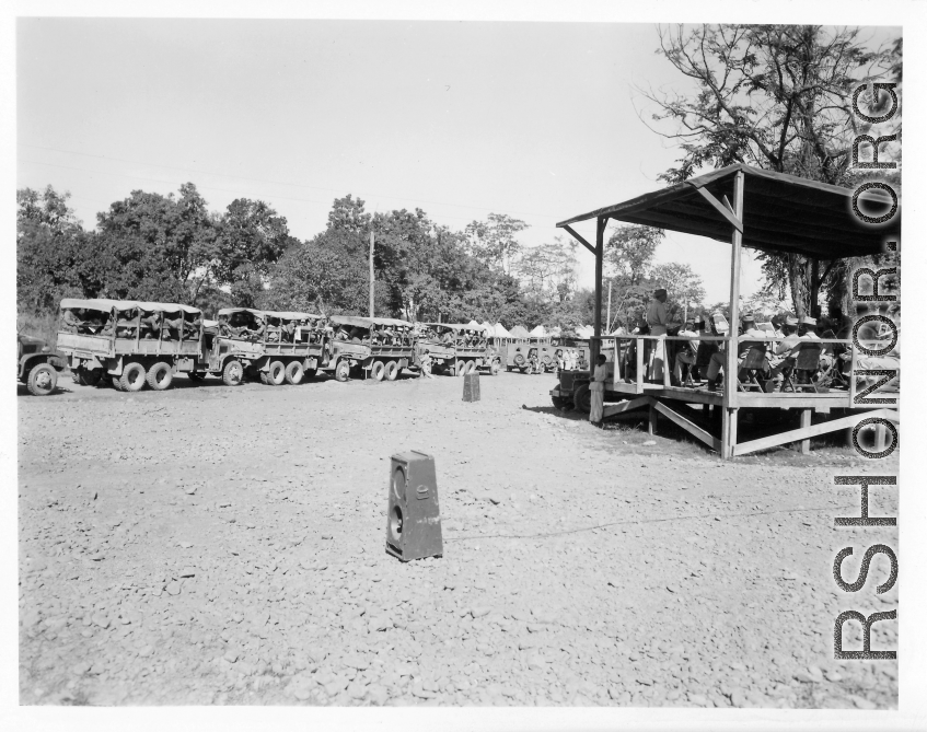 A convoy loaded with troops and engineers prepares to set out, while a band plays, and music projected to convoy via loudspeakers.  During WWII.
