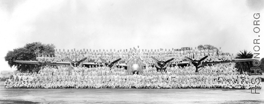 Personnel of the 9th Bombardment Squadron, 7th Bombardment Group, 10th Air Force, pose covering a B-24 bomber during WWII.