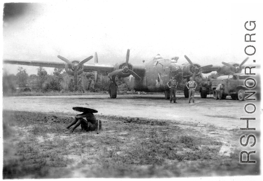 American flyers pose before B-24 "Doodlebug" In SW China as the bomber is being refueled.  During WWII.