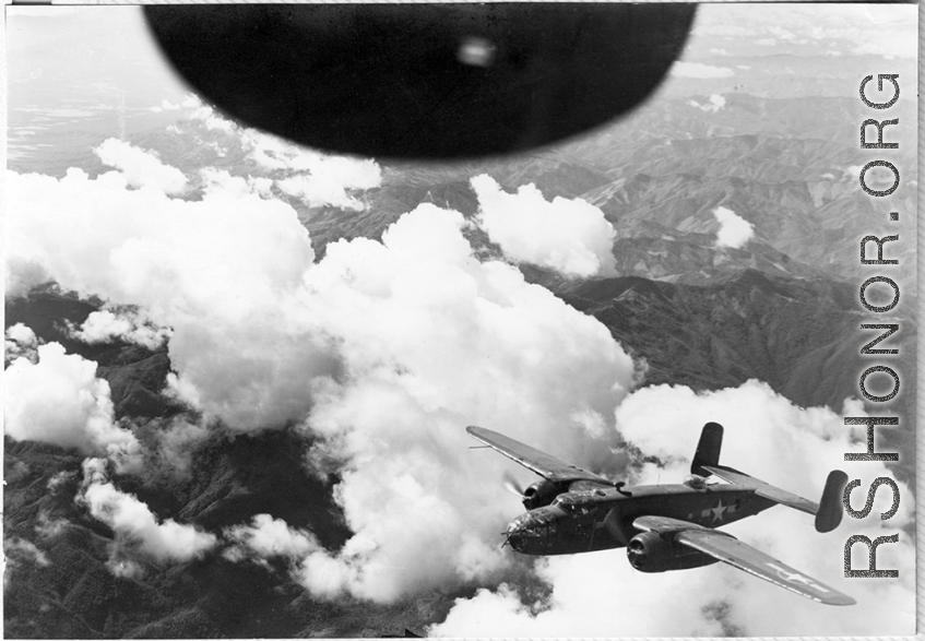 B-25s of the 22nd Bombardment Squadron in flight over rough mountains of SW China or Burma during WWII.