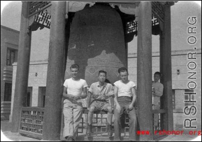 GIs of SACO and a Chinese soldier sit in front of a large cast bell, next to the Lanzhou City Hospital (兰州市立医院) in Gansu province, China, during WWII.